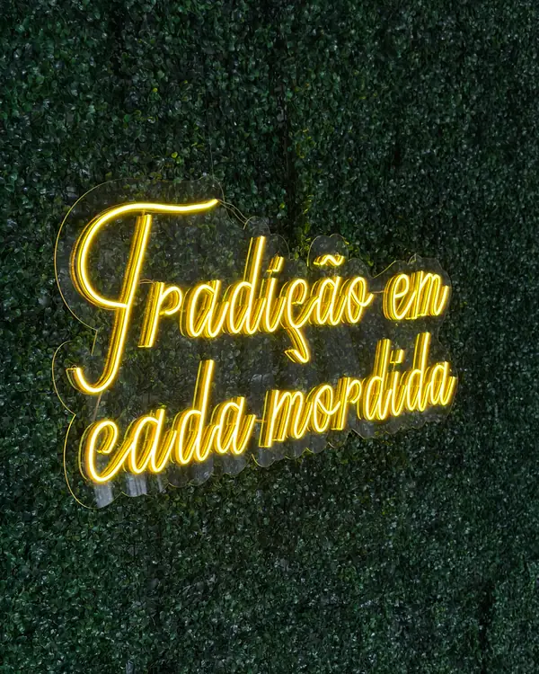 Frase em neon de LED amarelo sobre jardim vertical